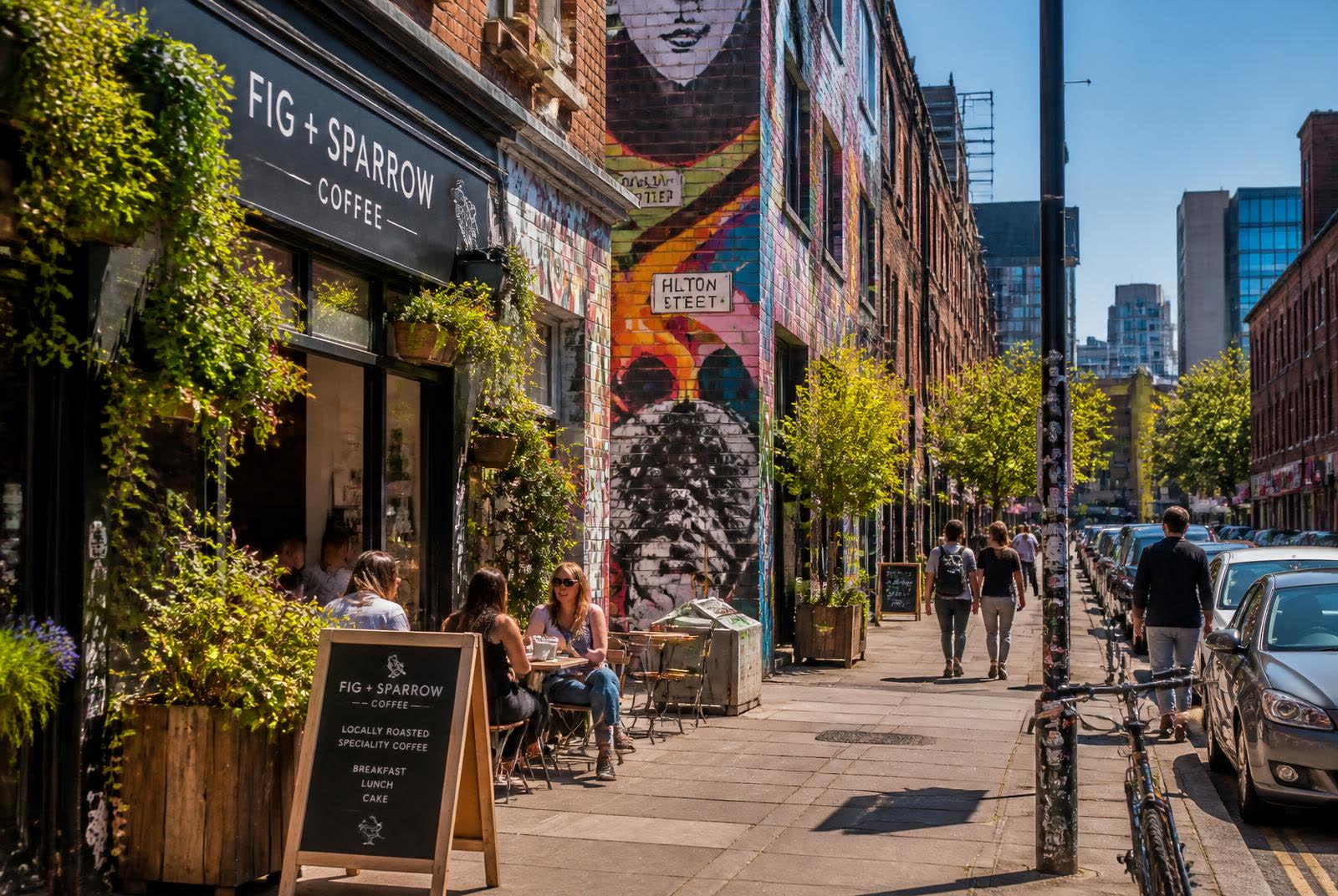 Northern Quarter street with murals, greenery and an independent coffee shop